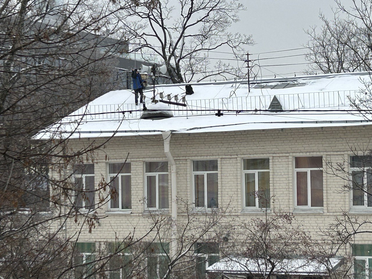 На Профессора Попова заметили коммунальщика без страховки на крыше школы